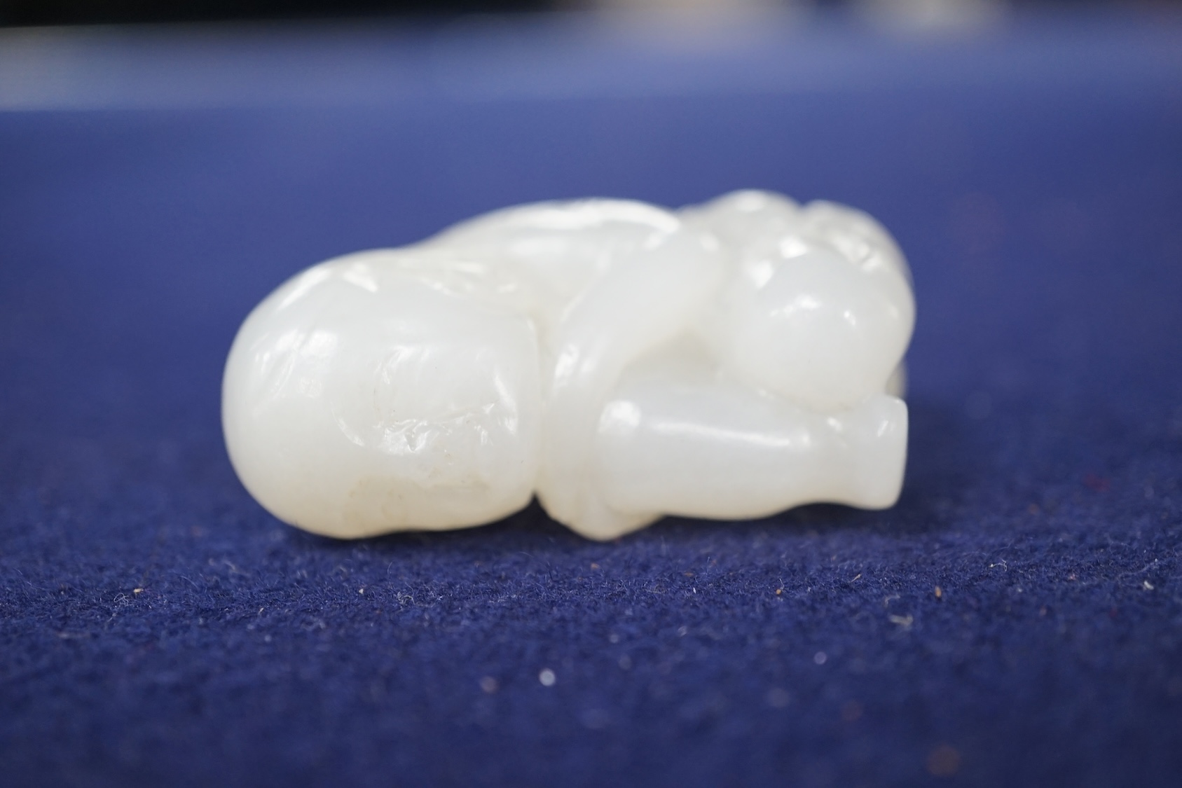 A Chinese white jade carving of a crouching figure, 4.5cm high. Condition - good